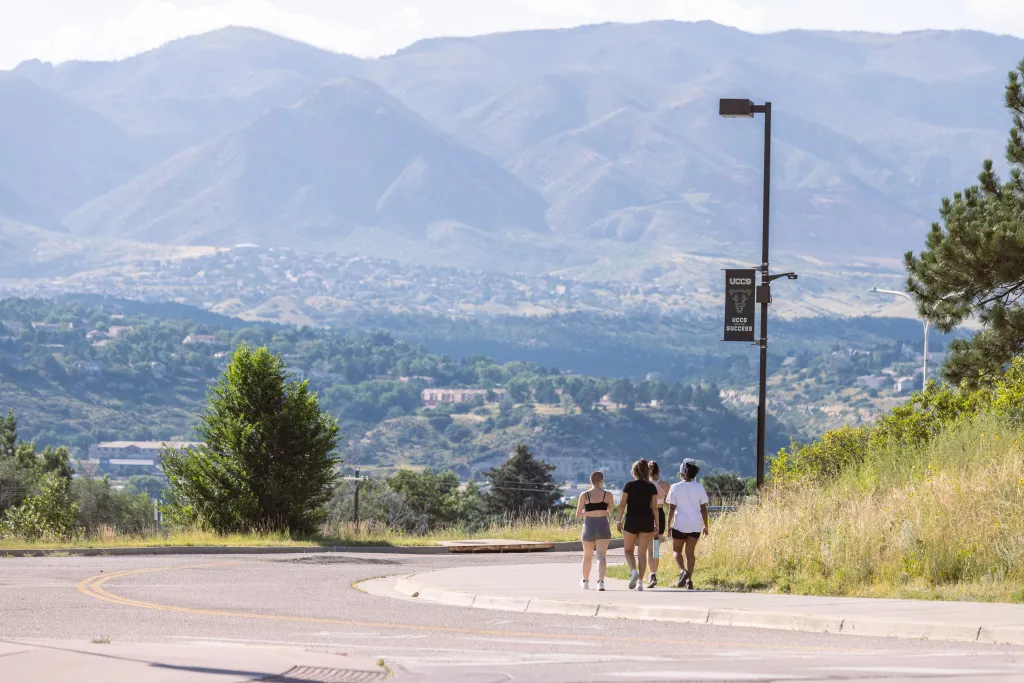 students walking on campus together with mountains in the background